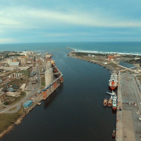 Fotografía aérea del puerto de Necochea, con un buque navegando.